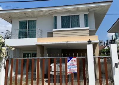 Exterior view of a modern two-story house with a gated entrance