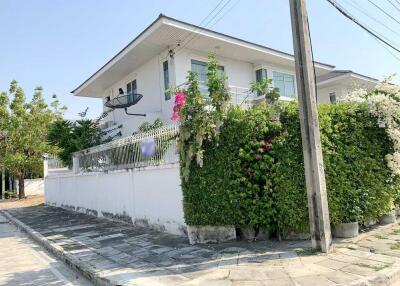 Exterior view of a house with garden and paved sidewalk