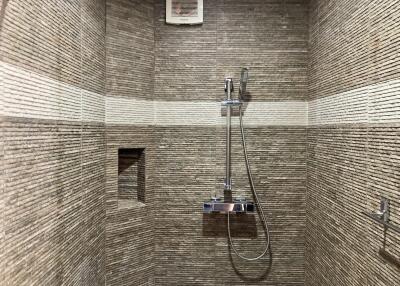 Modern shower area with textured tile walls