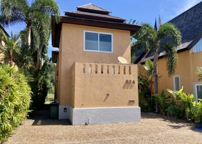 Two-story residential building with tropical landscaping