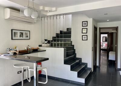 Modern living area featuring staircase and kitchen counter