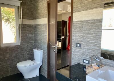 Modern bathroom with toilet and view into bedroom