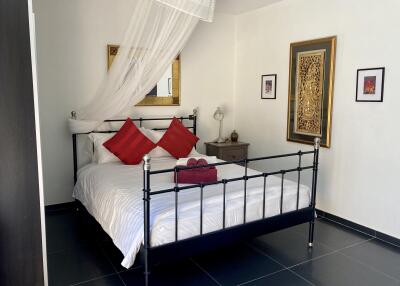 Modern bedroom with wrought iron bed and decorative pillows