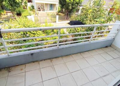 Spacious balcony with railing overlooking a garden and residential area