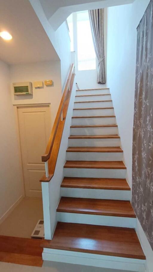 staircase leading to upper floor with wooden steps