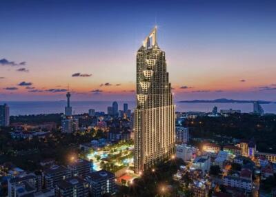 Panoramic view of a tall modern building at dusk, with cityscape and ocean in the background