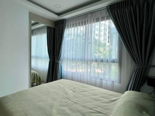 Bright and cozy bedroom with large windows and curtains