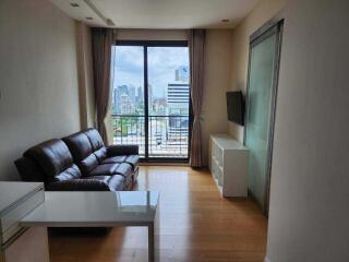 Modern living room with sofa, TV, and city view