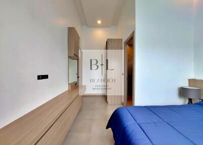 Modern bedroom with built-in wardrobe and blue bedding