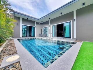 Outdoor swimming pool with adjacent modern house