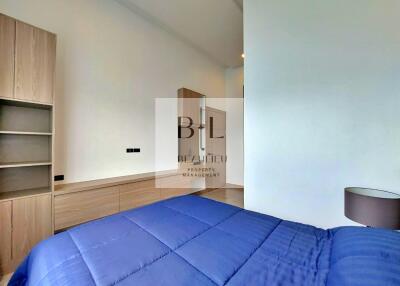 Bedroom with blue bedding and wooden furniture