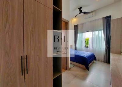 Modern bedroom with wooden wardrobe and large window