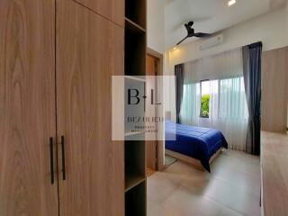 Modern bedroom with wooden wardrobe and large window