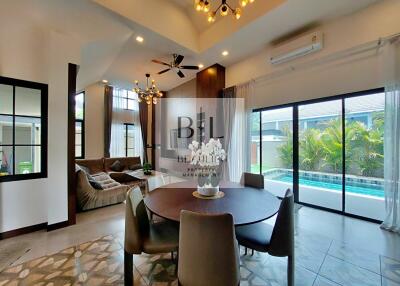 Spacious open-plan living and dining area with pool view