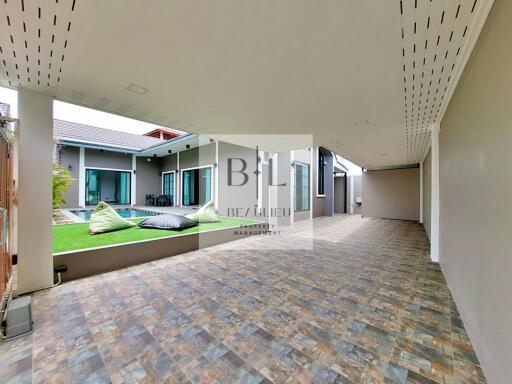 Spacious covered patio with view of modern house and garden