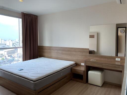 Spacious bedroom with wooden furniture and large window