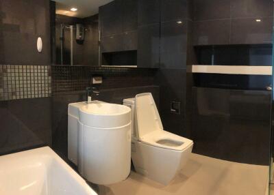 Modern bathroom with black tiles and white fixtures