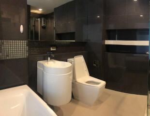 Modern bathroom with black tiles and white fixtures