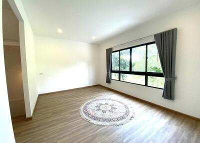 Spacious and well-lit living room with wooden flooring and a large window