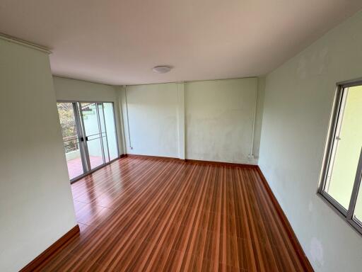 Spacious living room with wooden flooring and large windows