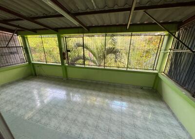 Enclosed outdoor space with tiled flooring and green walls