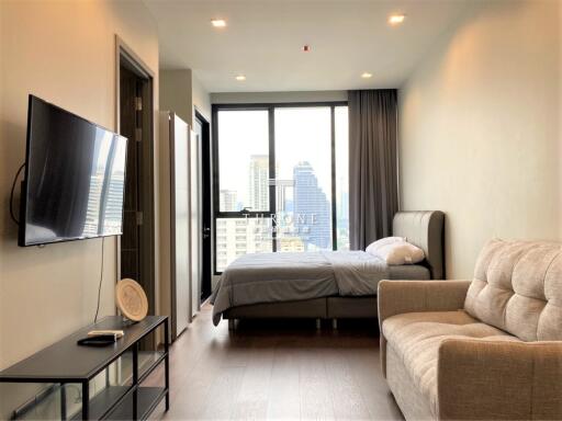 Modern bedroom with city view, TV, and comfortable seating