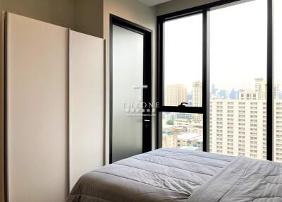 Modern bedroom with large windows and city view