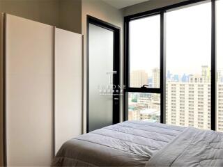 Modern bedroom with large windows and city view