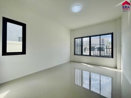 Empty living room with a large window and tiled floor