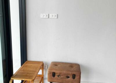 Small seating area with a leather stool and wooden rack