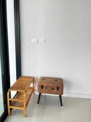 Small seating area with a leather stool and wooden rack