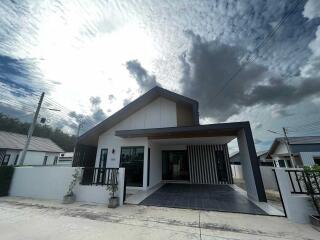 Modern single-story house with a unique roof design and driveway