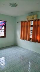 Empty bedroom with tiled floor and curtains on windows