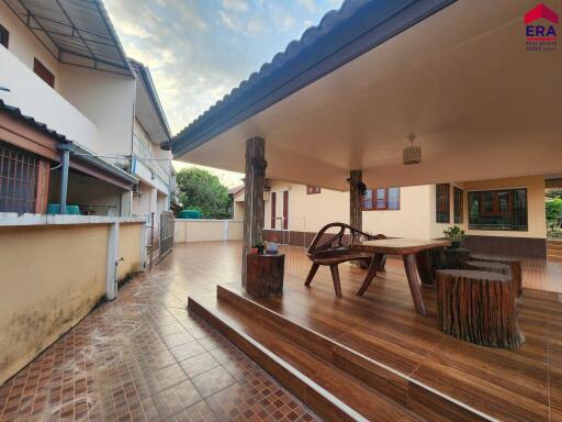 Outdoor covered seating area in building with wooden furniture