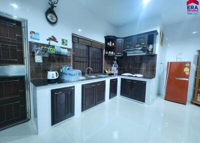 Modern kitchen with dark wood cabinets and full appliances