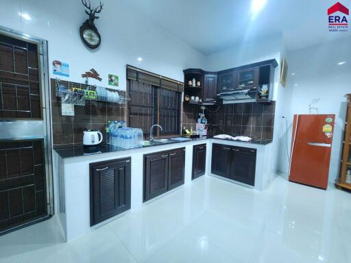 Modern kitchen with dark wood cabinets and full appliances