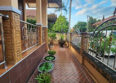 Nicely tiled outdoor patio area with potted plants and wrought-iron fencing