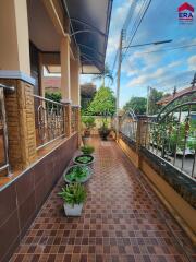 Nicely tiled outdoor patio area with potted plants and wrought-iron fencing