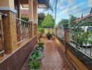 Nicely tiled outdoor patio area with potted plants and wrought-iron fencing