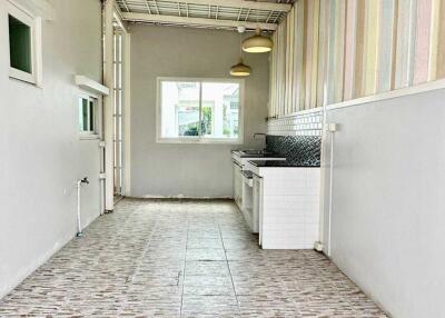 Long narrow kitchen with white walls, tiled floor, and hanging lights