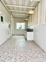 Long narrow kitchen with white walls, tiled floor, and hanging lights