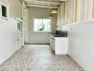 Long narrow kitchen with white walls, tiled floor, and hanging lights