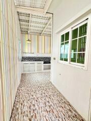 Bright kitchen with modern design including striped walls, white cabinets, tiled backsplash, and a large window