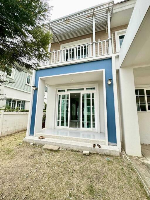 Two-story house front view with patio and balcony