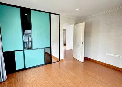 Spacious bedroom with wooden floors and sliding glass door closet