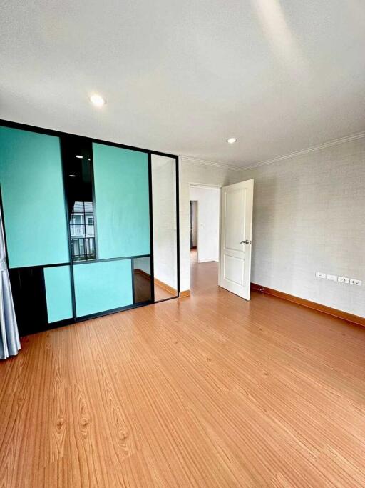 Spacious bedroom with wooden floors and sliding glass door closet