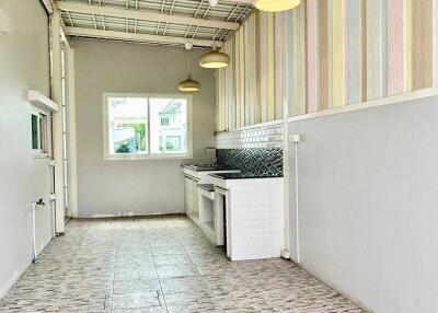 Spacious kitchen with striped walls and tiled flooring