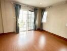 Spacious main living room with large windows and wooden flooring