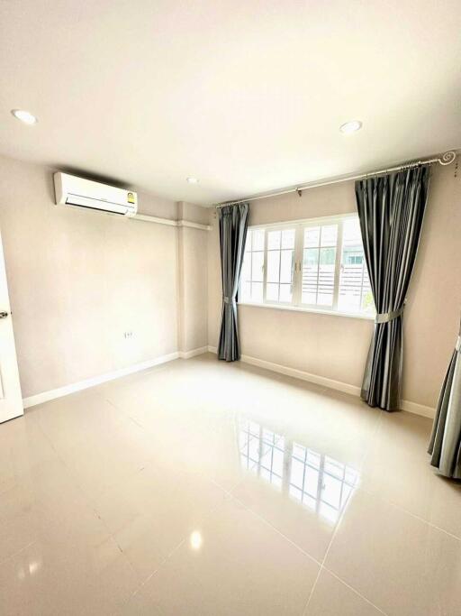 Bright bedroom with large window, air conditioning unit, and tiled floor