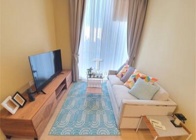 Modern living room with TV, sofa, and decorative rug